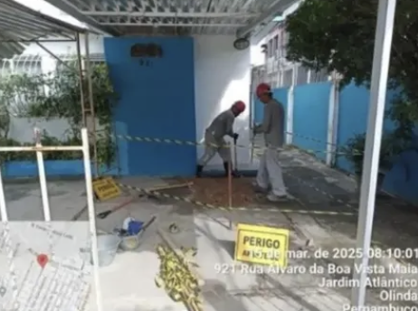 Profissionais avaliando área sinalizada junto à edificação